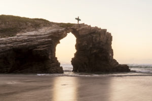 Spanien, Nordküste, Galicien, Nationalpark, Kathedralenstrand, Playa de las Catedrales, Surfer mit Brett auf Felsen Spanien, Nordküste, Galicien, Nationalpark, Kathedralenstrand, Playa de las Catedrales, Surfer mit Brett auf Felsen